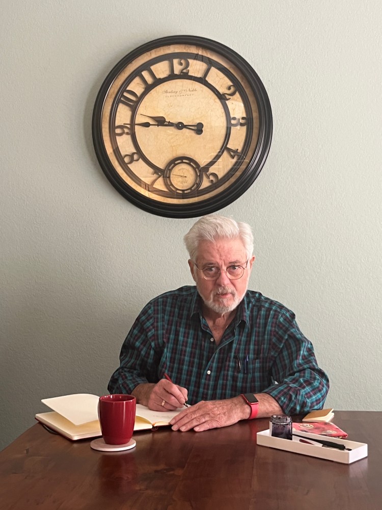 Robin writes in journal under big wall clock